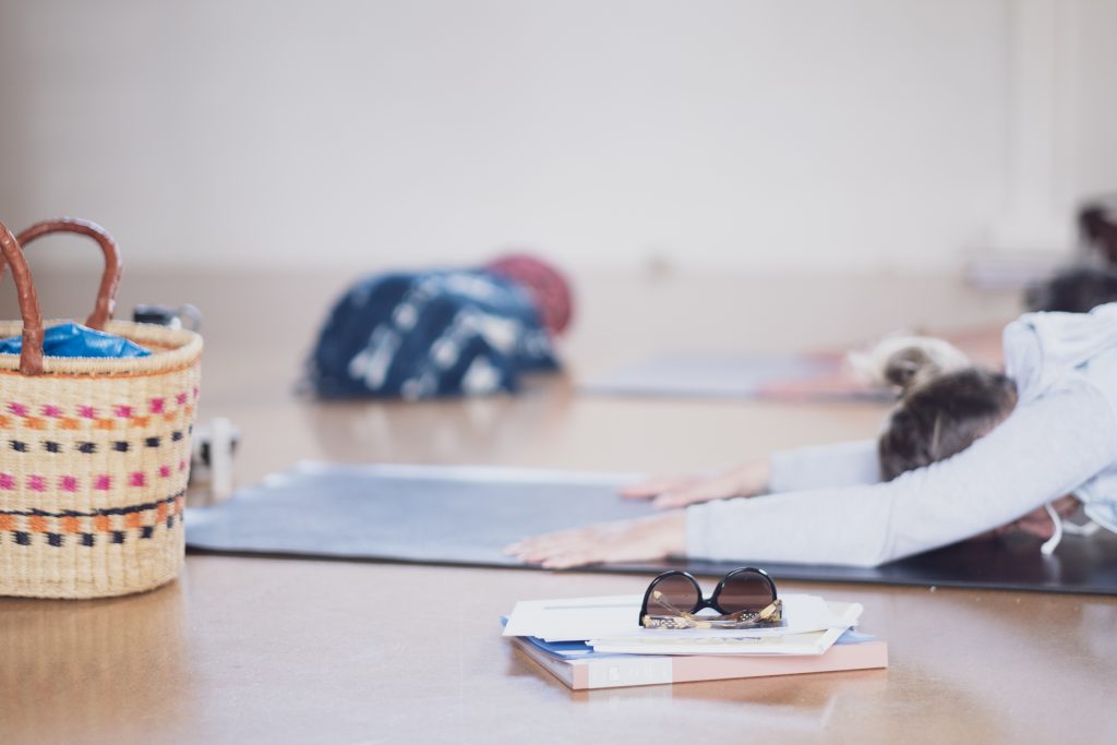 WOMEN IN A CHILD POSE AND BOOKS NEXT TO HER AT THE FREMANTLE YOGA STUDO