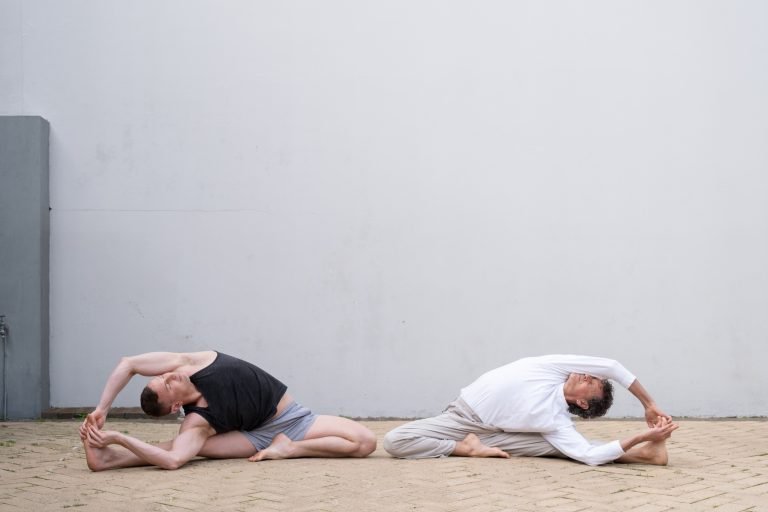 WALT AND JAMES IN A YOGA POSITION IN THE COURTYARD